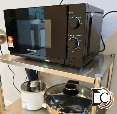 a microwave oven sitting on top of a shelf at Skudai - The 9 Homestay near UTM, Kangkar Pulai in Skudai