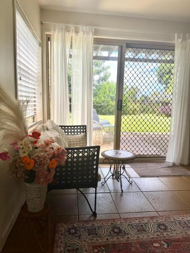 a living room with a couch and a table and a window at Beautiful, comfortable 7 mins walk to Mullumbimby in Mullumbimby