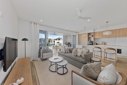 a living room with a couch and a table at Stylish 4-Bed Waterfront Home with Private Pool in Maroochydore