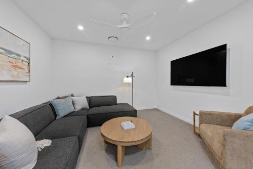 a living room with a couch and a table at Stylish 4-Bed Waterfront Home with Private Pool in Maroochydore