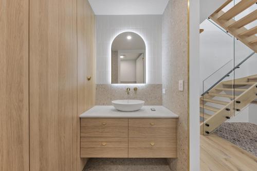 a bathroom with a sink and a staircase at Stylish 4-Bed Waterfront Home with Private Pool in Maroochydore