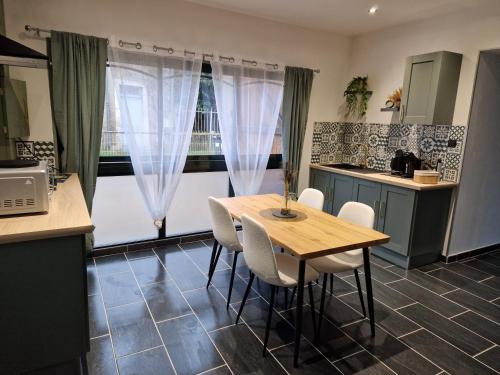 サン・タマン・モンロンにあるgrand Studio 2 personnesのテーブルと椅子と窓のあるキッチン