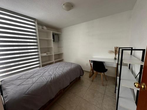 a bedroom with a bed and a desk and a window at Casa de Lucas in Balvanera