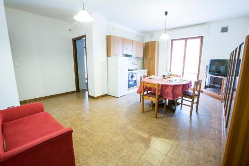 eine Küche und ein Esszimmer mit einem Tisch und einem roten Sofa in der Unterkunft Gemma 4 Pineto Vacanza in Pineto