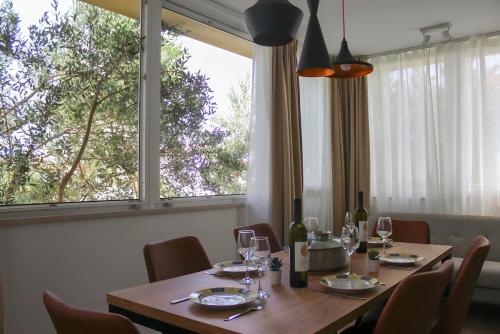 a dining room table with chairs and a large window at Grandma's house in Rogoznica