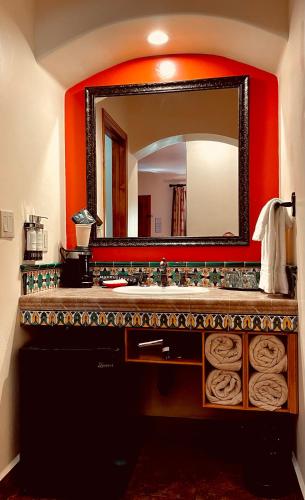 a bathroom with a sink and a large mirror at Los Arboles Hotel in Palm Springs