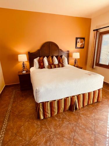 a bedroom with a large bed with two lamps at Los Arboles Hotel in Palm Springs