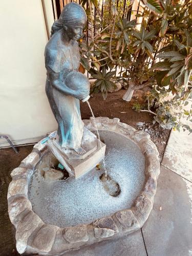 a statue of a girl playing in a fountain at Los Arboles Hotel in Palm Springs