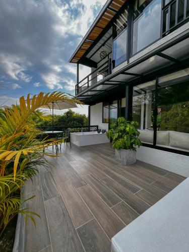 a house with a large patio with tables and plants at Finca Hotel Casa Nostra, villa Mariana in Quimbaya
