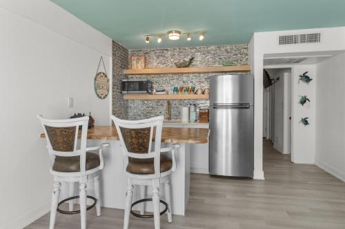 a kitchen with a bar and a refrigerator at Ocean Front and Pool Front At Daytona Inn Beach Resort in Daytona Beach