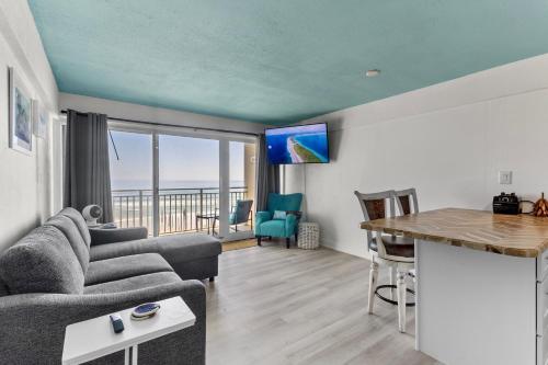 a living room with a couch and a table at Ocean Front and Pool Front At Daytona Inn Beach Resort in Daytona Beach