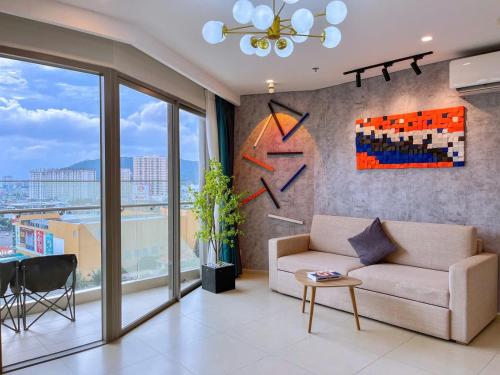 a living room with a couch and a large window at The Song Boutique Apartment in Vung Tau