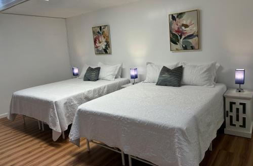 two beds in a room with two purple lamps at Downtown 2BR Huge Patio Free parking WiFi in Honolulu