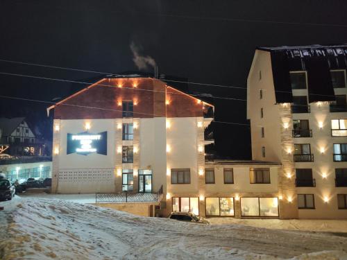 a building at night with snow on the ground at Apartman Alastra AP 02 President Kop in Kopaonik