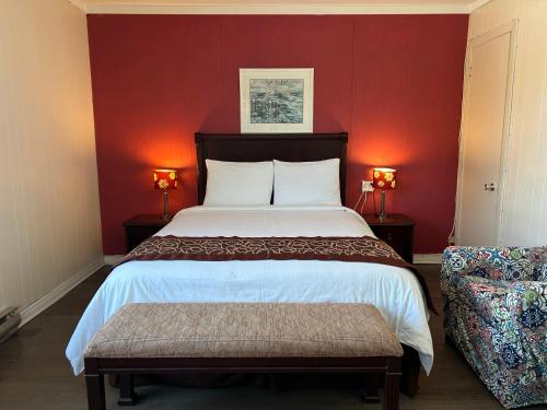 a bedroom with a large bed with red walls at Motel Chantolac in Sainte-Adèle