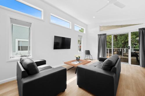 a living room with two black chairs and a table at Myrtleford Holiday Park in Myrtleford