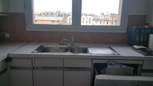 un comptoir de cuisine avec un évier et une fenêtre dans l'établissement Top Floor Apartment & Terrace with View, à Paris