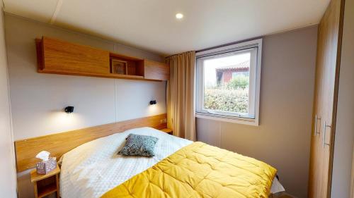una camera con letto giallo e finestra di Camping Le Marisol 5 étoiles Torreilles Plage a Torreilles