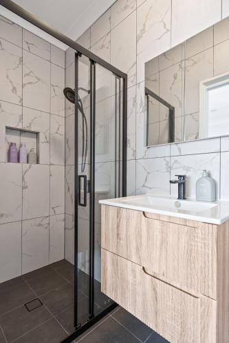 a bathroom with a sink and a shower at Newcastle Escape 4-Bedroom House in Hamilton