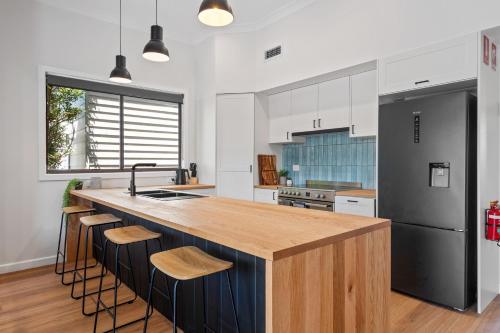 a kitchen with a large island with a wooden counter top at Newcastle Escape 4-Bedroom House in Hamilton