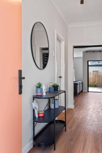 a living room with a black shelf and a mirror at Newcastle Escape 4-Bedroom House in Hamilton