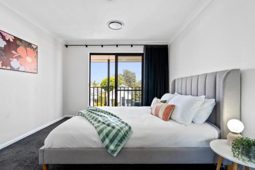 a bedroom with a bed and a window at Newcastle Escape 4-Bedroom House in Hamilton