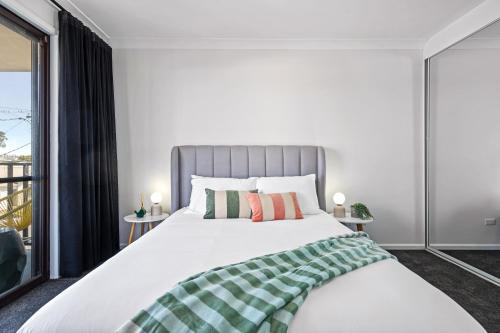a bedroom with a large bed and a balcony at Newcastle Escape 4-Bedroom House in Hamilton
