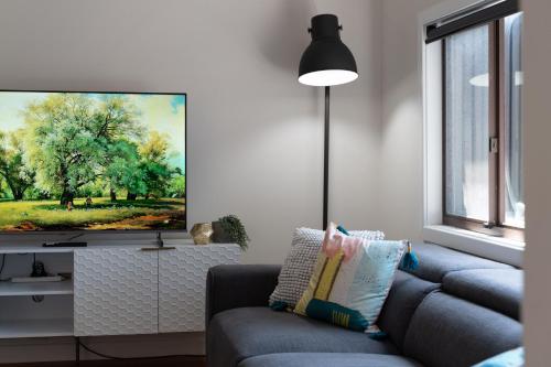 a living room with a couch and a painting on the wall at Newcastle Escape 4-Bedroom House in Hamilton
