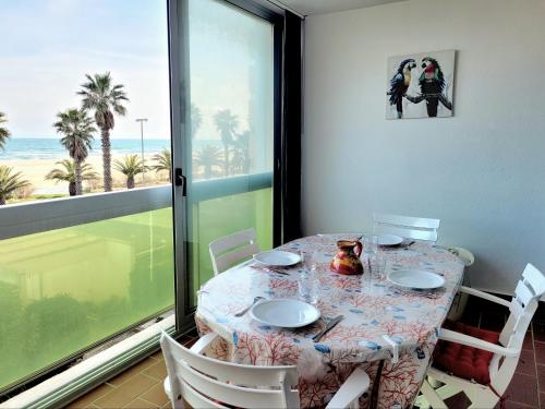 une salle à manger avec une table et une vue sur la plage dans l'établissement Canet-en-Roussillon - T2 moderne - Accès plage - Parking privé - FR-1-794-120, à Canet