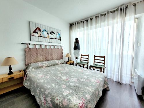 une chambre avec un lit et deux chaises et une fenêtre dans l'établissement Canet-en-Roussillon - T2 moderne - Accès plage - Parking privé - FR-1-794-120, à Canet