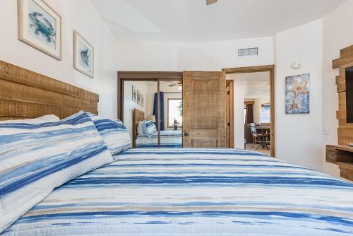 a bedroom with a bed with a blue and white comforter at Right on the Beach! Ground Floor Princesa E104 in Puerto Peñasco