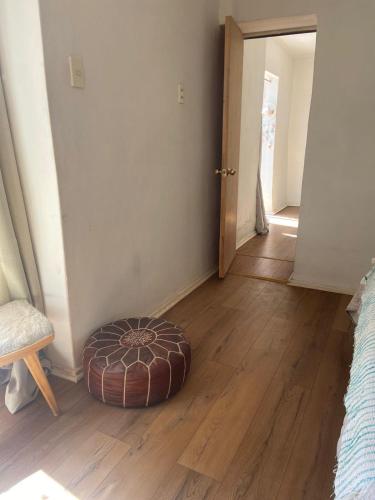 a room with a ottoman sitting on a wooden floor at Yunkai Home in Vicuña