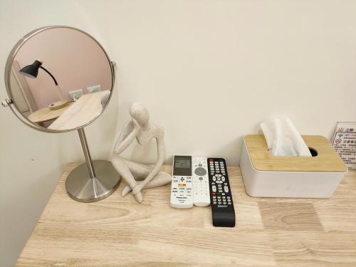 a mirror and a doll sitting on a table with a remote control at 山之間特色民宿 自助入住 包棟附電動麻將 in Yuli