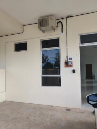 a white wall with a window and a door at Puteri Homestay in Kangar