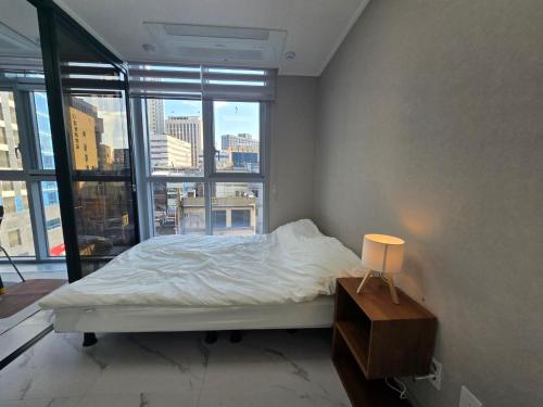 a bedroom with a bed and a large window at Urban Square in Seoul