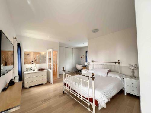 une chambre avec un lit blanc et une salle de bain dans l'établissement Villa avec piscine chauffée, à Soulac-sur-Mer