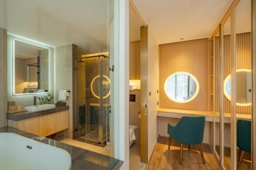 a bathroom with a shower and a sink and a mirror at La Green Hotel and Residence in Bang Tao Beach