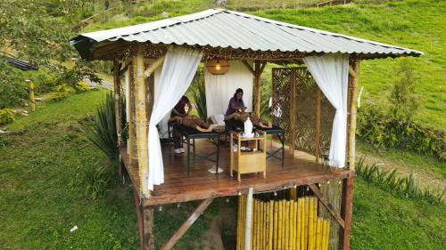 a group of people sitting in a gazebo at MACA GLAMPING in Calima