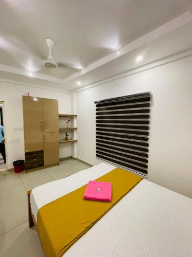 a bedroom with a bed with a pink purse on it at SM Suites in Kakkanad