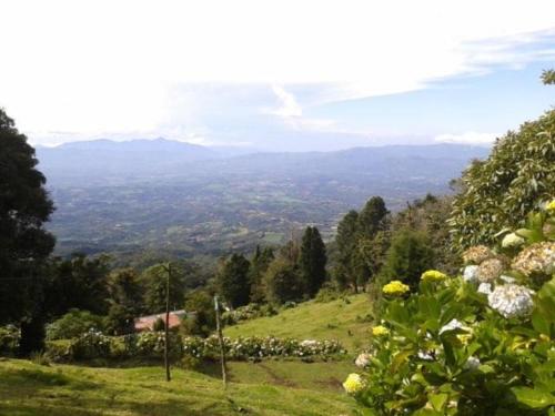 a green hillside with a view of a valley at Cabaña Rústica Elena in Poás