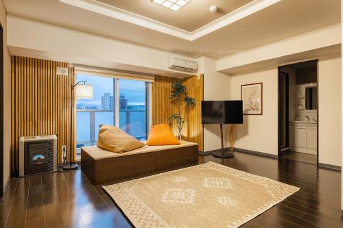 a living room with a couch and a television at Cozy Stay Sapporo Hongodori 405 in Sapporo