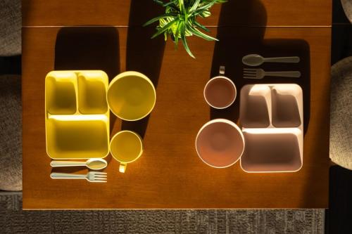 a wooden table with cups and utensils on it at Cozy Stay Sapporo Hongodori 405 in Sapporo