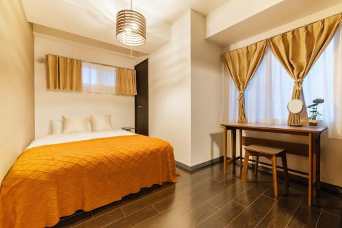 a bedroom with a bed and a desk and window at Cozy Stay Sapporo Hongodori 405 in Sapporo