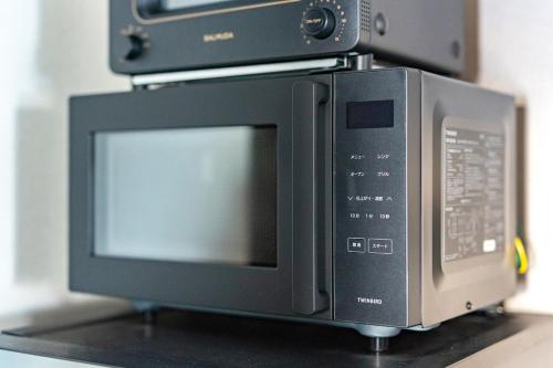 a microwave oven sitting on top of a counter at Cozy Stay Sapporo Hongodori 405 in Sapporo