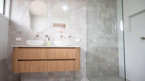 une salle de bain avec deux lavabos et une douche dans l'établissement Blue Haven Pet Friendly Retreat, à McCrae