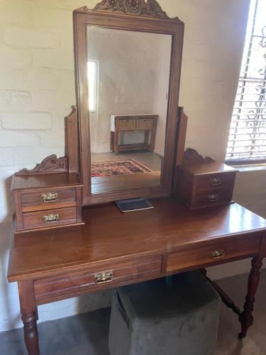 a wooden desk with a mirror on top of it at Hartland Country House Luxury Double Rooms in Oudtshoorn