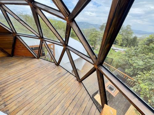 a view from the inside of a building with a wooden deck at MACA GLAMPING in Calima