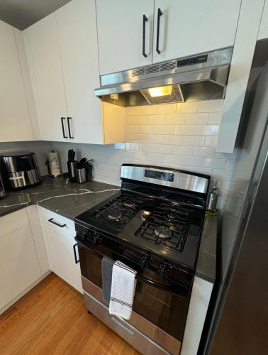 a kitchen with a stove and white cabinets at Luxury Gated NYC Theme 3BR 2B with Parking by EWR in Elizabeth