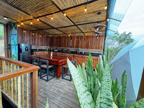 an outdoor kitchen with a table and chairs on a deck at MACA GLAMPING in Calima