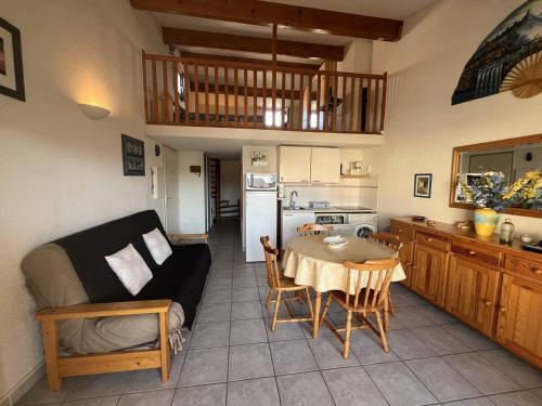 Il comprend un salon et une cuisine avec une table et un canapé. dans l'établissement T3 climatisé avec parking et piscine à 200m de la plage au Cap d'Agde - FR-1-749-75, au Cap d'Agde